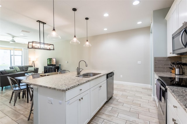 17847 Althea Blue Pl, Lutz, FL 33558 - kitchen with appliances with stainless steel finishes, a sink, tasteful backsplash, recessed lighting, and ceiling fan