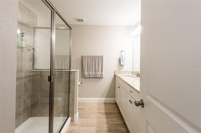17847 Althea Blue Pl, Lutz, FL 33558 - bathroom featuring vanity, a stall shower, baseboards, and wood finished floors
