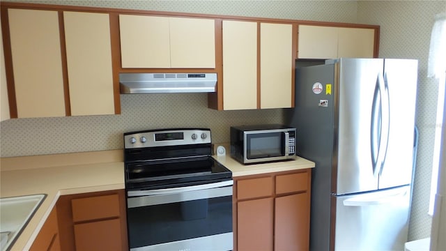4736 Sunny Loop, Holiday, FL 34690 - kitchen featuring under cabinet range hood, stainless steel appliances, wallpapered walls, light countertops, and a sink