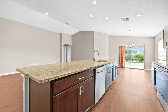 6937 Gideon Cir, Zephyrhills, FL 33541 - kitchen featuring a sink, stainless steel appliances, light wood-style flooring, arched walkways, and vaulted ceiling