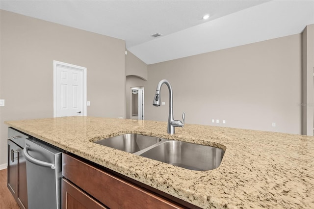 6937 Gideon Cir, Zephyrhills, FL 33541 - kitchen with a sink, wood finished floors, light stone counters, vaulted ceiling, and arched walkways