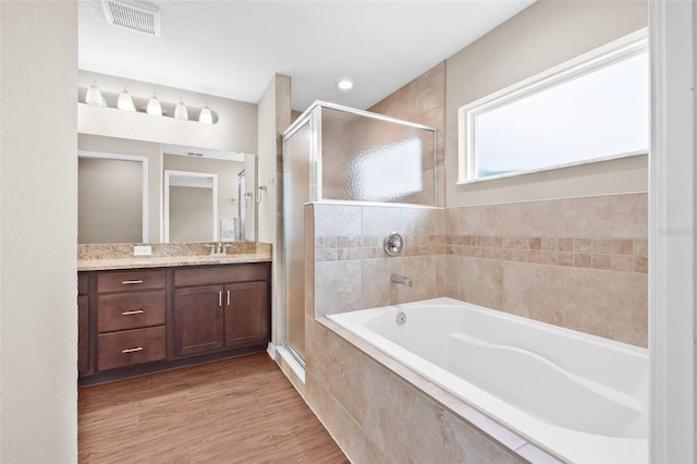 6937 Gideon Cir, Zephyrhills, FL 33541 - full bathroom featuring a shower stall, a bath, vanity, wood finished floors, and a baseboard radiator