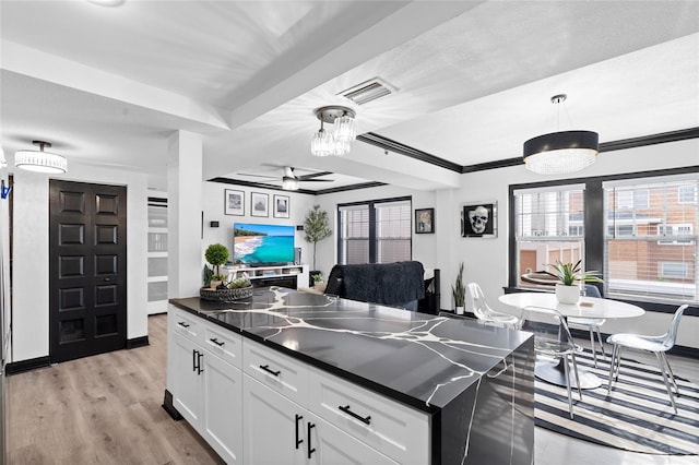 219 4th Ave N Unit 201, Saint Petersburg, FL 33701 - kitchen featuring dark countertops, a ceiling fan, white cabinets, hanging light fixtures, and light wood-style floors