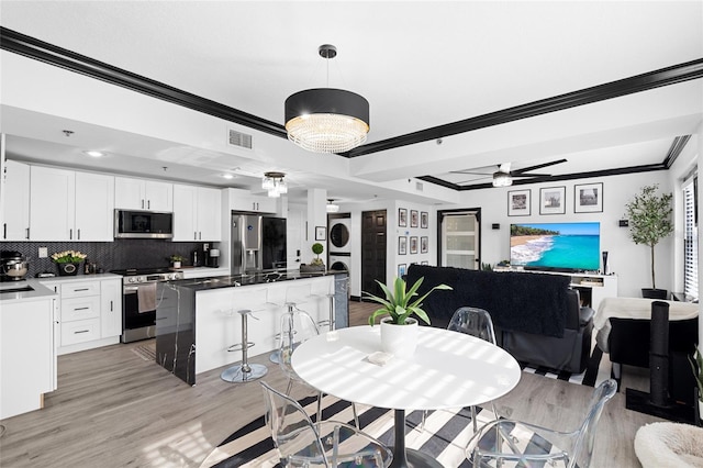 219 4th Ave N Unit 201, Saint Petersburg, FL 33701 - dining space with ornamental molding, a ceiling fan, and light wood finished floors
