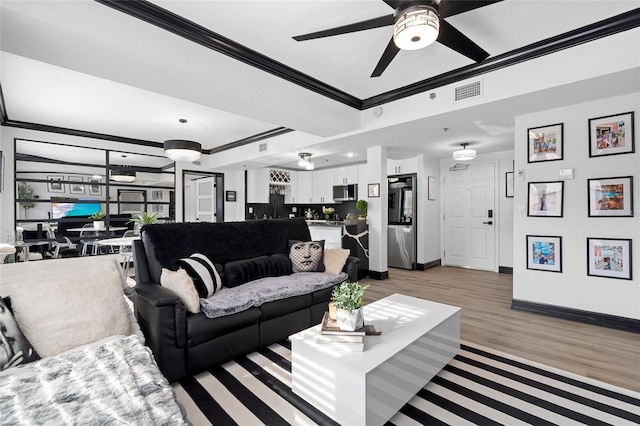 219 4th Ave N Unit 201, Saint Petersburg, FL 33701 - living room featuring crown molding, baseboards, ceiling fan, light wood-style floors, and a tray ceiling
