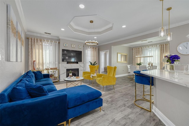 2722 Via Tivoli Unit 430A, Clearwater, FL 33764 - living area with wood finished floors, a high end fireplace, a tray ceiling, ornamental molding, and recessed lighting