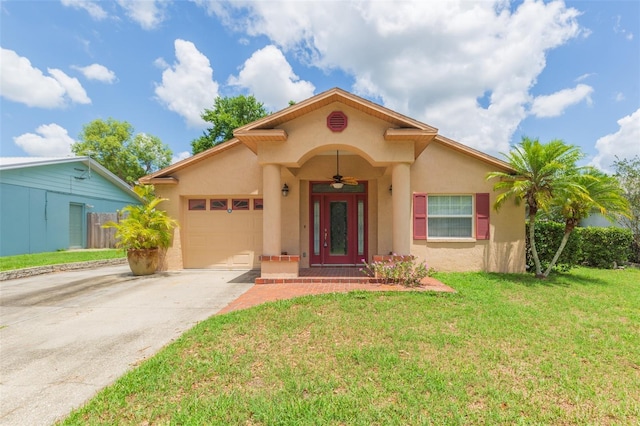mediterranean / spanish house with stucco siding, a garage, concrete driveway, and a front yard