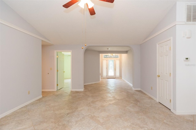 empty room with arched walkways, lofted ceiling, and ceiling fan