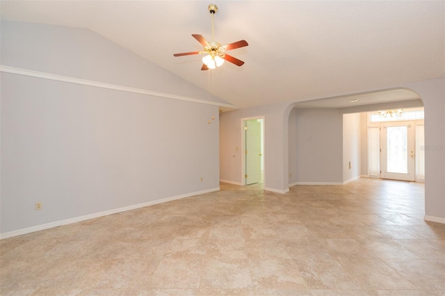 spare room with arched walkways, lofted ceiling, ceiling fan, and baseboards
