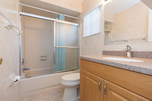 bathroom with shower / bath combo with shower curtain, toilet, vanity, and tile patterned floors