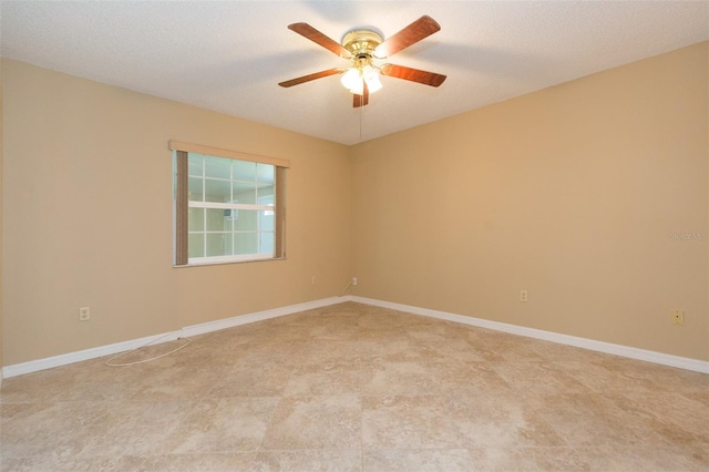 empty room with ceiling fan and baseboards