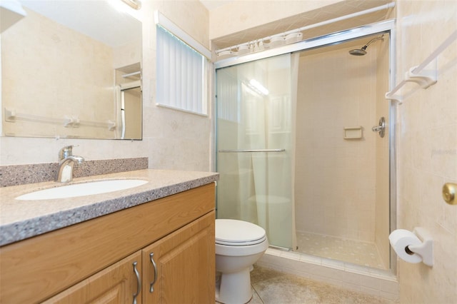 full bathroom featuring a stall shower, toilet, tile patterned flooring, vanity, and tile walls