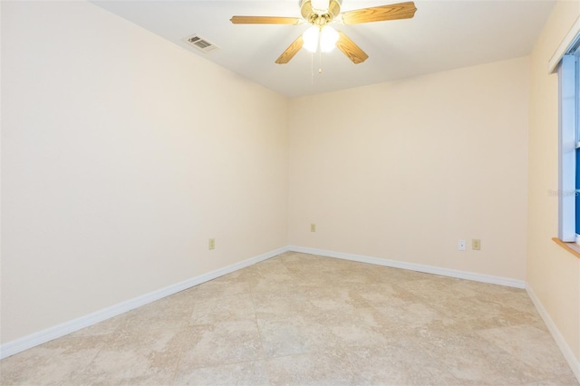 unfurnished room featuring ceiling fan and baseboards