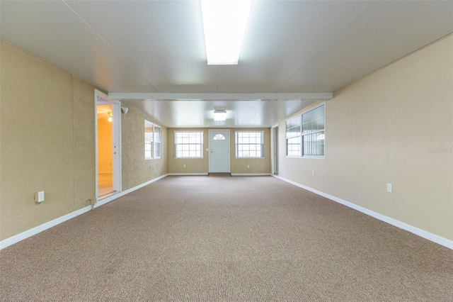 carpeted empty room with baseboards