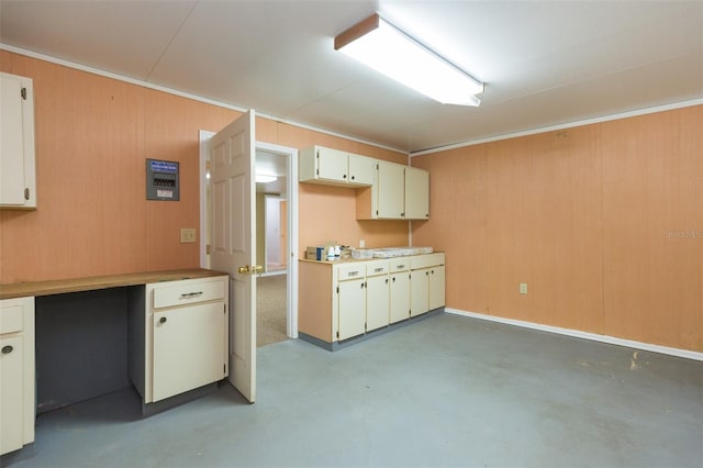 kitchen with concrete flooring, light countertops, and ornamental molding