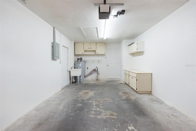 garage featuring a sink, electric panel, and a garage door opener