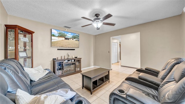 living area featuring ceiling fan, light tile patterned floors, and a textured ceiling