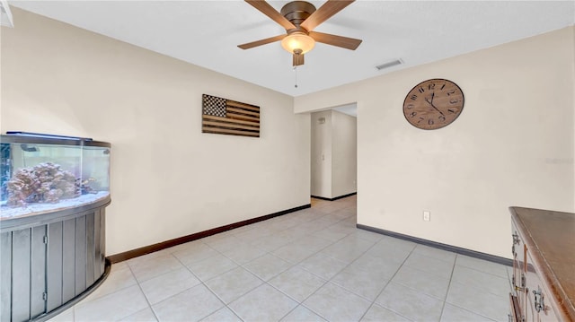spare room featuring ceiling fan, baseboards, and light tile patterned flooring