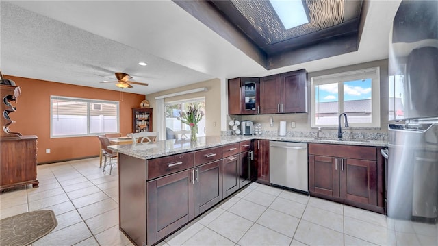 kitchen featuring appliances with stainless steel finishes, a sink, a peninsula, healthy amount of natural light, and recessed lighting