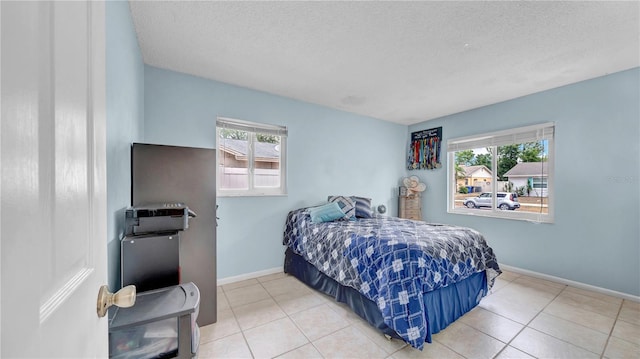 bedroom with baseboards, a textured ceiling, and tile patterned floors