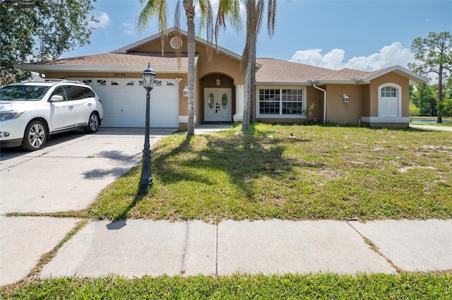 10149 Briar Cir, Hudson, FL 34667 - view of front of property featuring a garage, stucco siding, concrete driveway, and a front lawn