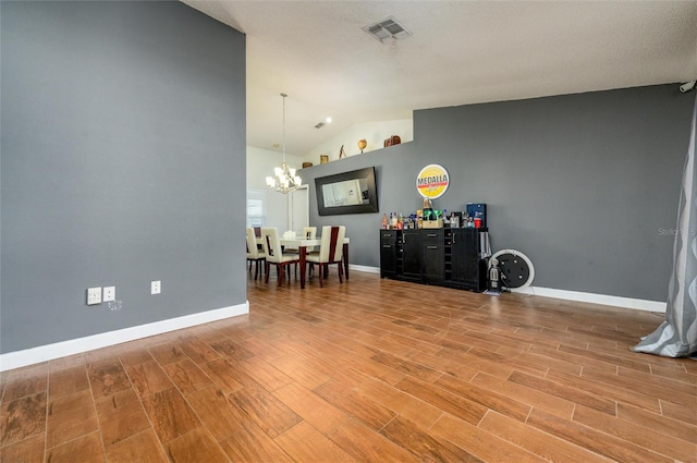 10149 Briar Cir, Hudson, FL 34667 - living area featuring a chandelier, vaulted ceiling, wood finished floors, and baseboards