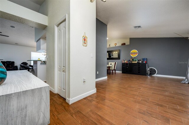10149 Briar Cir, Hudson, FL 34667 - hallway with wood finished floors, baseboards, a textured ceiling, and vaulted ceiling