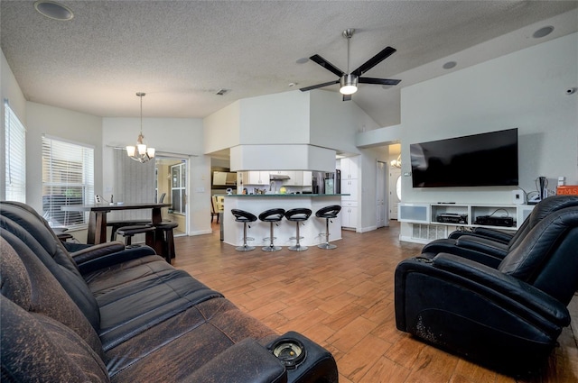 10149 Briar Cir, Hudson, FL 34667 - living area featuring wood finished floors, a textured ceiling, a chandelier, ceiling fan, and baseboards