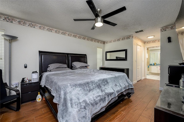 10149 Briar Cir, Hudson, FL 34667 - bedroom with dark wood finished floors, a textured ceiling, baseboards, and ceiling fan