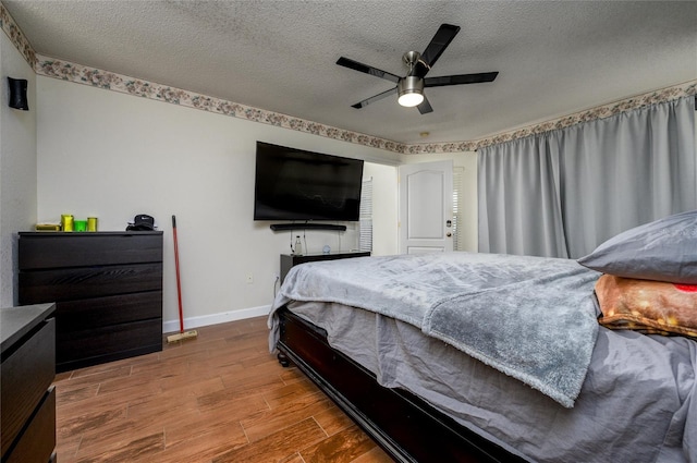 10149 Briar Cir, Hudson, FL 34667 - bedroom with wood finished floors, baseboards, a textured ceiling, and a ceiling fan