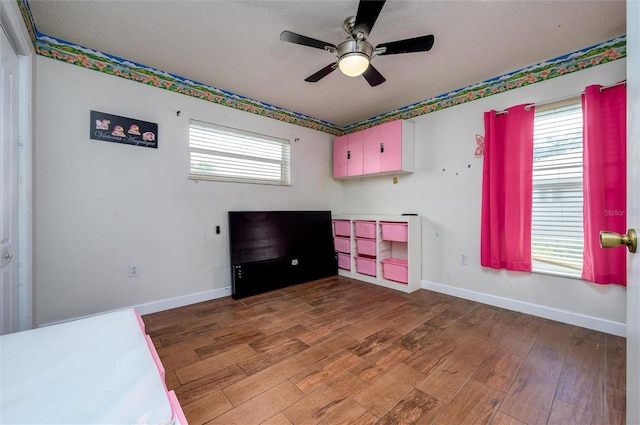 10149 Briar Cir, Hudson, FL 34667 - unfurnished bedroom featuring wood finished floors, baseboards, a ceiling fan, and a textured ceiling