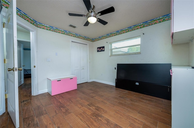 10149 Briar Cir, Hudson, FL 34667 - unfurnished bedroom with wood finished floors, a textured ceiling, a closet, baseboards, and a ceiling fan
