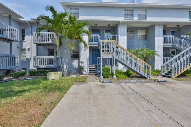 4801 W Mcelroy Ave Unit D104, Tampa, FL 33611 - view of front facade featuring stairs, uncovered parking, and stucco siding