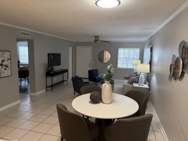 4801 W Mcelroy Ave Unit D104, Tampa, FL 33611 - dining space featuring a textured ceiling, light tile patterned floors, ornamental molding, a ceiling fan, and baseboards