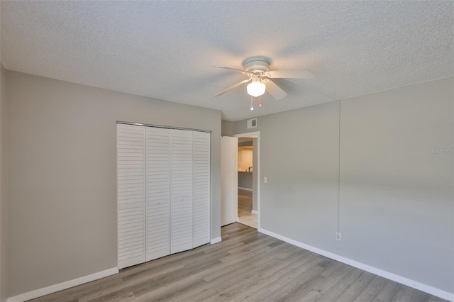 4801 W Mcelroy Ave Unit D104, Tampa, FL 33611 - unfurnished bedroom with wood finished floors, a closet, baseboards, a textured ceiling, and ceiling fan