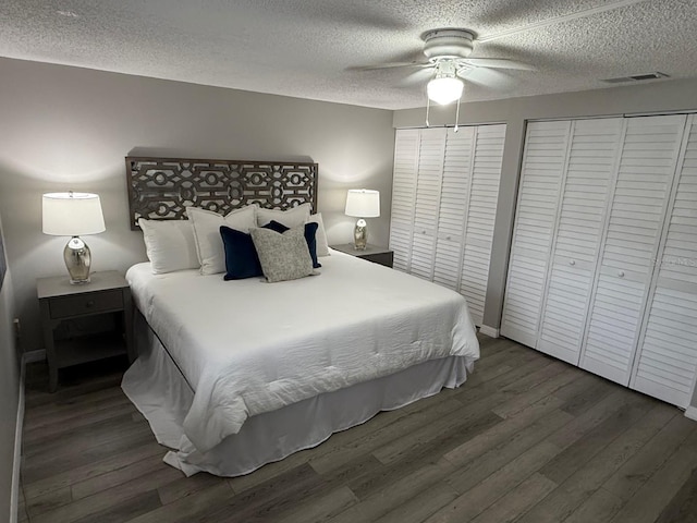 4801 W Mcelroy Ave Unit D104, Tampa, FL 33611 - bedroom featuring two closets, wood finished floors, a textured ceiling, and a ceiling fan