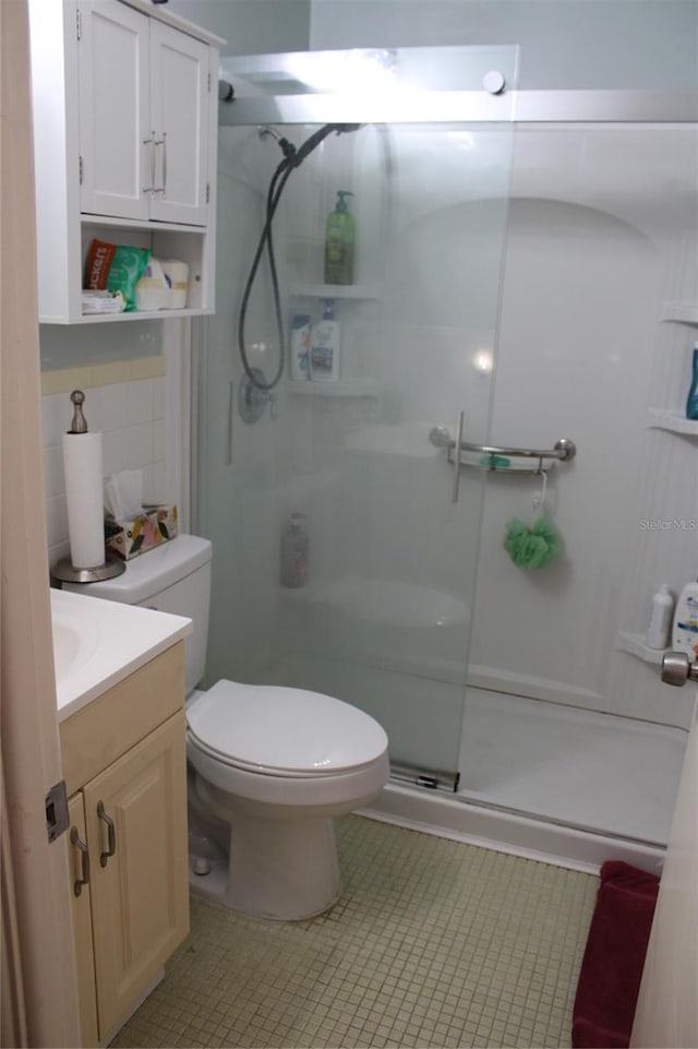 2020 World Parkway Blvd Unit 12, Clearwater, FL 33763 - full bath featuring a stall shower, toilet, vanity, tile patterned flooring, and tasteful backsplash