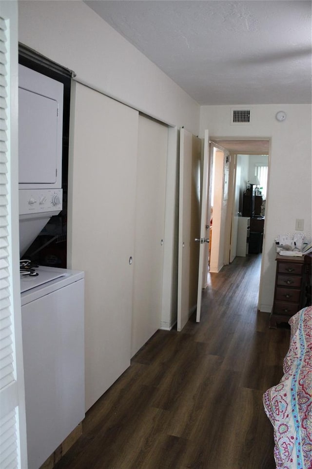 2020 World Parkway Blvd Unit 12, Clearwater, FL 33763 - bedroom with stacked washer / drying machine, dark wood-style floors, and a closet