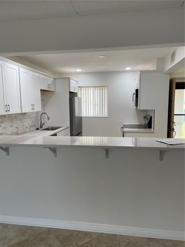 kitchen with stainless steel appliances, a sink, and a kitchen bar