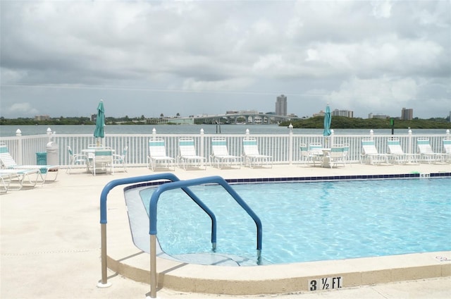 community pool with fence and a patio area