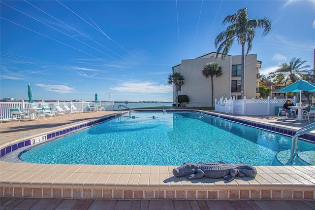 community pool with fence and a patio