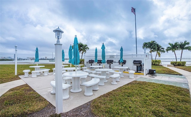 surrounding community with a lawn and a water view