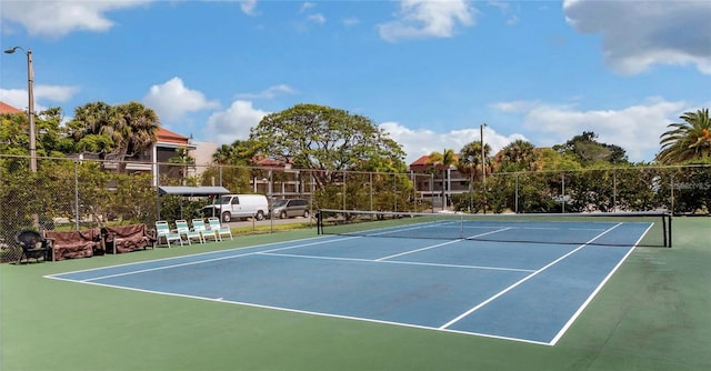 view of tennis court featuring fence and community basketball court