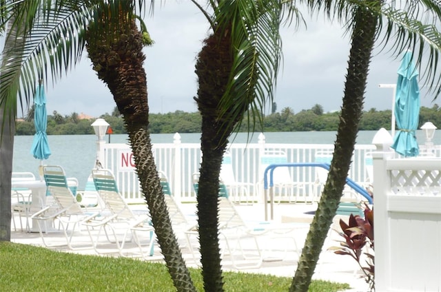 view of pool featuring a water view and fence