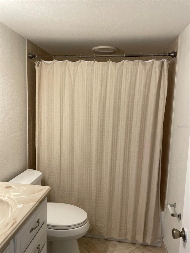 845 S Gulfview Blvd Unit 110, Clearwater Beach, FL 33767 - full bathroom with vanity, toilet, tile patterned floors, a textured ceiling, and a shower with shower curtain