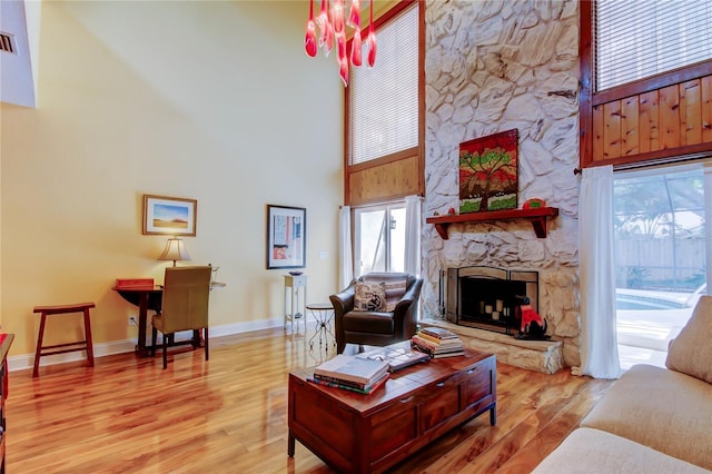 3406 Hollyhock Way, Tampa, FL 33618 - living room with a towering ceiling, a stone fireplace, wood finished floors, baseboards, and plenty of natural light