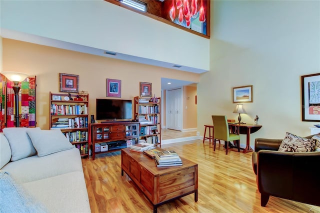 3406 Hollyhock Way, Tampa, FL 33618 - living area with light wood finished floors, baseboards, and a towering ceiling