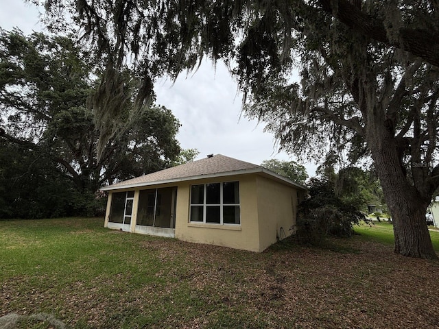 2846 N Kittery Pt, Hernando, FL 34442 - back of property featuring stucco siding, a lawn, a sunroom, and roof with shingles