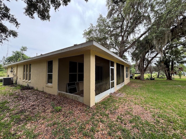 2846 N Kittery Pt, Hernando, FL 34442 - view of side of home featuring a sunroom, stucco siding, cooling unit, and a lawn