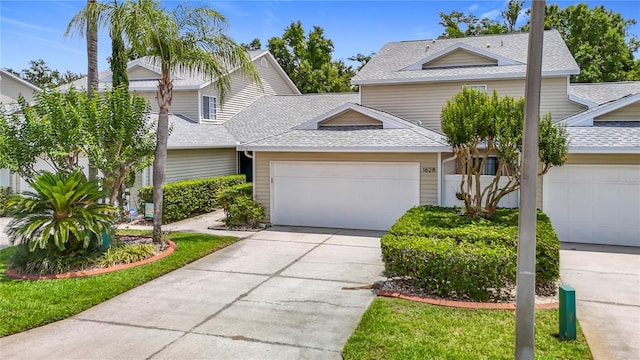 1628 Lullwater Ln, Lutz, FL 33549 - view of front facade featuring a garage, a shingled roof, and concrete driveway